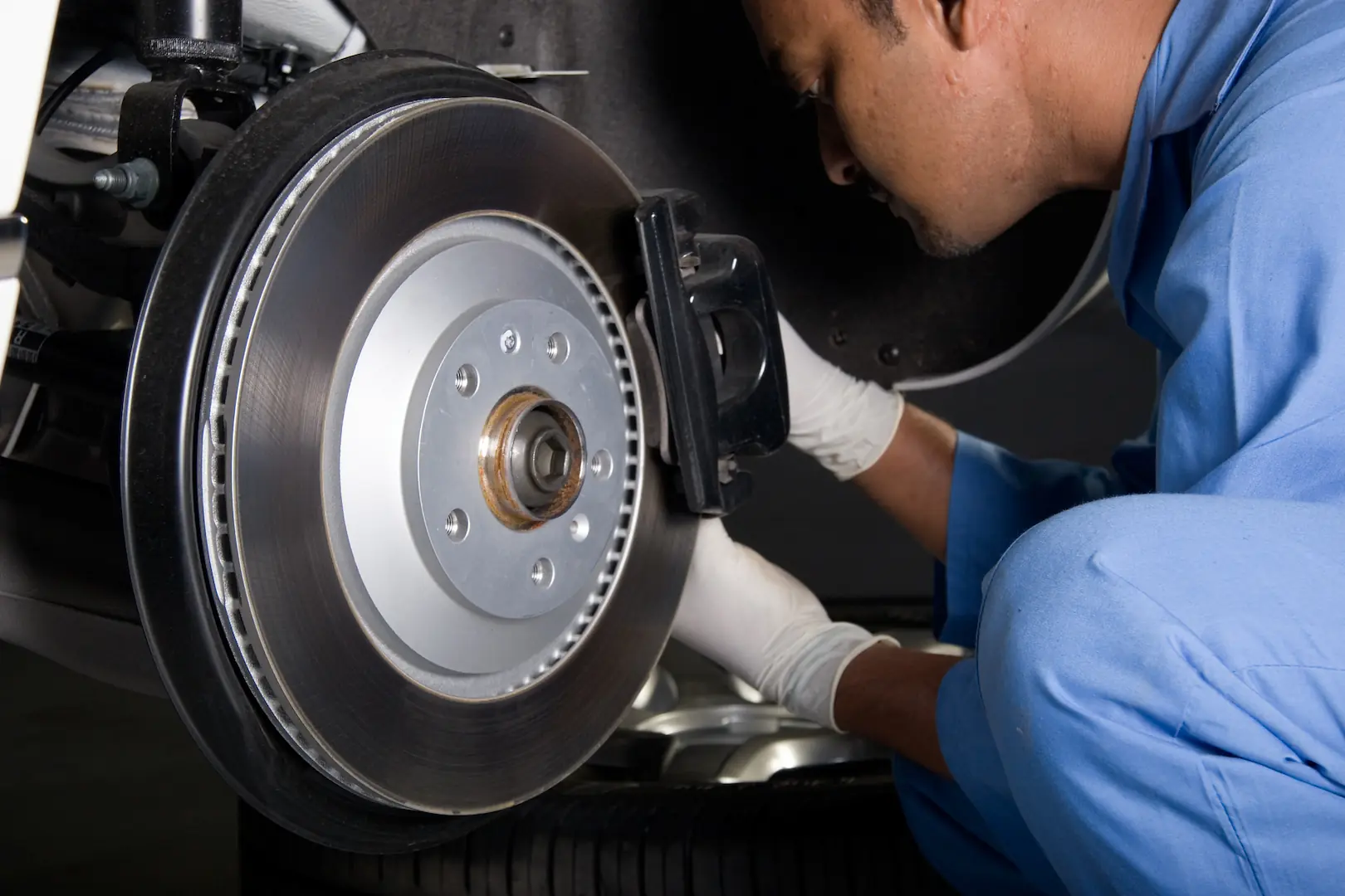 Technician performing scheduled maintenance on a car engine